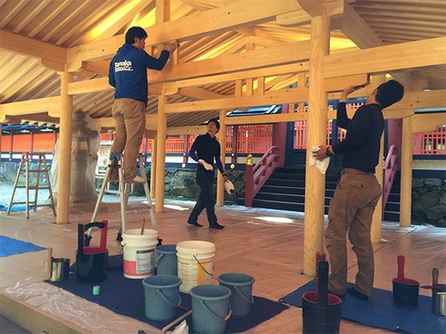 写真３　完成した神社拝殿を洗う若い職人たち（株）田中美装提供