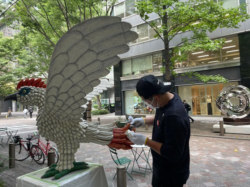 写真４　屋外設置されたアート作品を洗う職人（株）田中美装提供